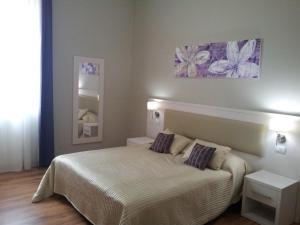 Lodges le Mura في فلورنسا: غرفة نوم عليها سرير ووسادتين