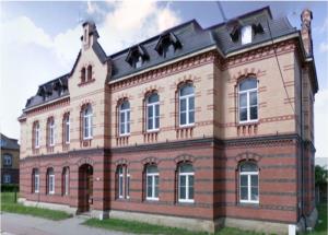 een groot bakstenen gebouw met een zwart dak bij Zimmerfrei-Dresden mit Bad-Miniküche Self Check In 24-7 in Dresden