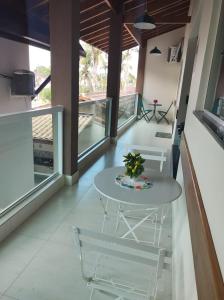 a table and chairs in a room with a balcony at Lar da Erica in Ubatuba