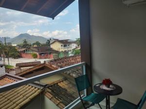 einen Balkon mit einem Tisch und Stühlen sowie Aussicht in der Unterkunft Lar da Erica in Ubatuba