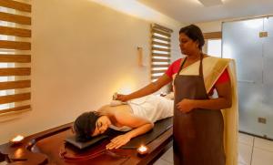 a woman getting her hair done in a mirror at Lhasa Ayurveda and Wellness Resort - A BluSalzz Collection, Kochi, Kerala in Cochin