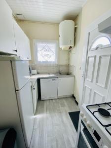 ビスカロッスにある22 RUE DES LIBELLULES -090の小さなキッチン(白い冷蔵庫付)、窓が備わります。