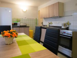 a kitchen with a table and some chairs and a stove at Apartmán Pod Ledovcem in Mladé Buky