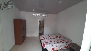 a bedroom with a bed with red flowers on it at Casa piscina in Mariquita