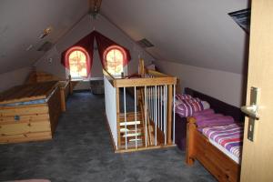 Zimmer mit einem Dachgeschoss mit einem Kinderbett und einem Schlafzimmer in der Unterkunft Fewo Schillings in Kodersdorf