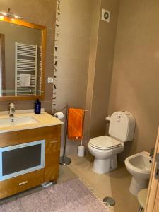 a bathroom with a toilet and a sink and a mirror at Perola Mar in Nazaré +23 photos