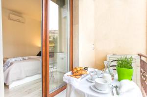 a room with a table and a room with a bed at RelaisApartments PORTO in Alghero