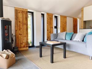 sala de estar con sofá y mesa en La Petite Grange, en Villars-sur-Ollon