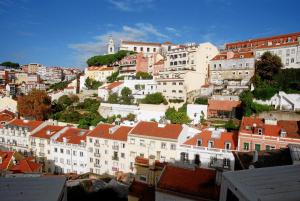 a view of a city with buildings and a church at Hostel do Castelo Lisboa in Lisbon