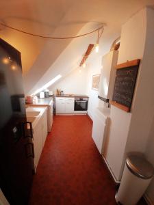 a kitchen with white cabinets and a red floor at Best of Chartres one bedroom city center and view on the Cathedral in Chartres