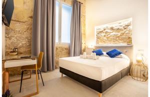 Habitación de hotel con cama, escritorio y mesa. en MyFlats Luxury Downtown, en Alicante