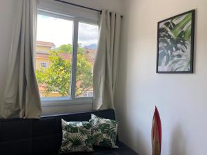 sala de estar con ventana y sofá en Flat Villaggio Juquehy, en Juquei