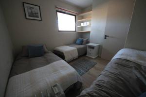 阿爾加羅沃的住宿－San Alfonso del Mar, Departamento 2D+2B, Kayak，一间卧室设有两张床和窗户。