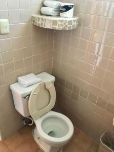 uma casa de banho com WC e toalhas numa prateleira em Hotel Club Akumal Caribe em Akumal