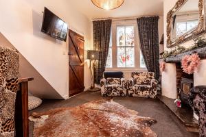 - un salon avec deux chaises et une cheminée dans l'établissement Quadrant Cottage, à Buxton