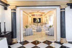ein Festsaal mit weißen Tischen und Stühlen in der Unterkunft Hotel Capital with private wellness in Nitra