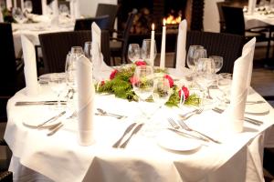 einen Tisch mit einem weißen Tischtuch mit Brille und Besteck in der Unterkunft Hotel Restaurant Telgter Hof in Telgte