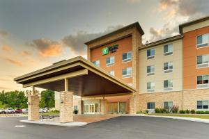 Holiday Inn Express & Suites - Saugerties - Hudson Valley, an IHG Hotel في ساوغيرتيس: تقديم مبنى للفندق مع وجود مواقف للسيارات
