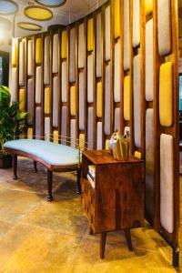 a bench and a table in a room at HALF Hotel, Calangute in Calangute