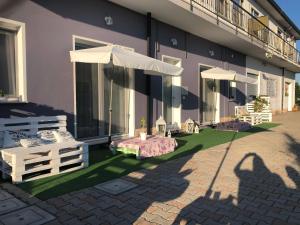 a patio with a table and umbrellas in front of a building at Mare&Terra... Alloggi nel Delta in Polesine Camerini
