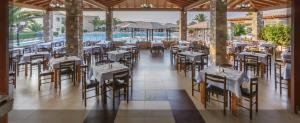 a restaurant with tables and chairs and a pool at Akti Beach Club in Kardamaina