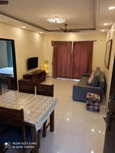 a living room with a couch and a table at Areia De Goa Luxury Condo in Arpora