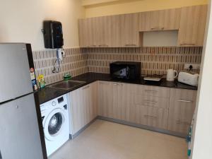 a kitchen with a washing machine and a washer at Areia De Goa Luxury Condo in Arpora