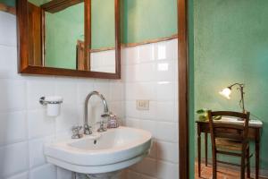 y baño con lavabo y espejo. en Podere La Casetta - Casa di Campagna, en Montaione