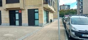 biały van zaparkowany obok ulicy obok budynku w obiekcie ZARAUTZ LOFT 1 w mieście Zarautz