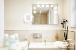 a bathroom with a sink and a mirror at Kampowski Apartments Bad Nauheim in Bad Nauheim +19 photos