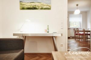 a desk in a living room next to a dining room at Kampowski Apartments Bad Nauheim in Bad Nauheim