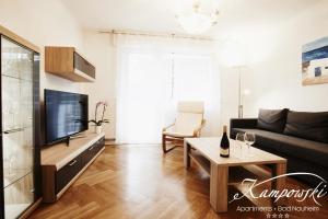 a living room with a couch and a tv at Kampowski Apartments Bad Nauheim in Bad Nauheim