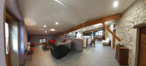 a living room with a couch and a stone wall at GITES LES MAISONS ROUGES in Jasseron