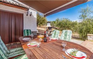 einen Holztisch und Stühle auf einer Terrasse in der Unterkunft Cortijo Sylvestris in Periana