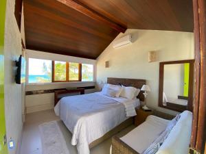 um quarto com uma cama grande e uma janela em Casa pé na areia da praia de geribá em búzios recém reformada - House "foot in the sand" of Geribá beach in Búzios recently renovated em Búzios