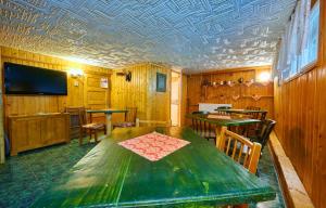 a dining room with a green table and chairs at Pensiunea Panorama in Băile Tuşnad