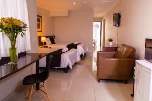 a hotel room with two beds and a chair at El Angolo in Lima