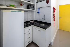 a small kitchen with a sink and a stove at Studio frente mar no Leme para 2 pessoas in Rio de Janeiro