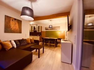 ein Wohnzimmer mit einem Sofa und einem Esszimmer in der Unterkunft Apartment Mitterberger - Nassfeld in Tröpolach