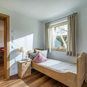 sypialnia z drewnianym łóżkiem i oknem w obiekcie Appartement Holaus w mieście Westendorf