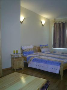 a bedroom with two beds and a table in it at Guest House Antoaneta in Nesebar