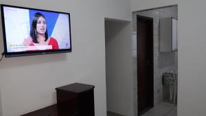 een flatscreen-tv aan een muur in een kamer bij Sua Casa na Praia da Costa 10 Esta Tem Ar Condicionado Internet 2Q Completa Geladeira Fogao TV Centro in Vila Velha