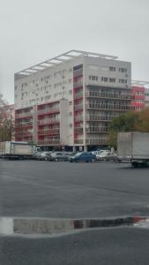 a large building with cars parked in a parking lot at Sweet Residence Apartment in Arad