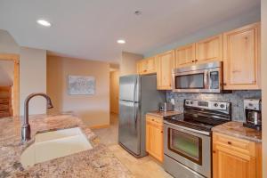 a kitchen with stainless steel appliances and wooden cabinets at Taylor's Crossing #210 condo in Copper Mountain