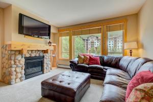 sala de estar con sofá y chimenea en Taylor's Crossing #210 condo, en Copper Mountain