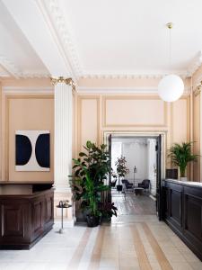een kamer met een gang met planten en een plafond bij The Columbia in Londen