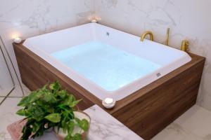 a hot tub in a bathroom with a bathtubificialificialificialificialificialificial at La Bella Ostuni Suites in Ostuni