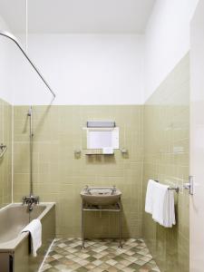 a bathroom with a bath tub and a sink at The Columbia in London