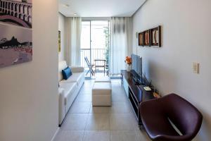 sala de estar con sofá y TV en Confortável e seguro 2 quartos com varanda no Leme, en Río de Janeiro