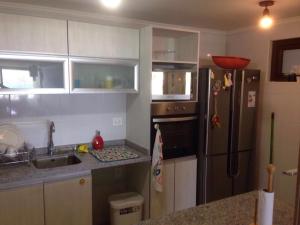 a kitchen with a stainless steel refrigerator and a sink at Departamento Jardín del Mar in Coquimbo